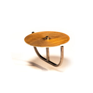 O Anel una Or é feito em fio quadrado, banhado em ródio negro, que contorna dois dedos, e sustenta chapa circular fosca, com banho de ouro 750.