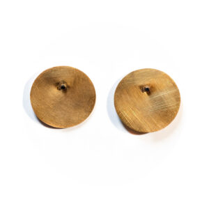 O Brinco una Or é feito em chapa circular fosca, banhada de ouro 750 e conectada a um pino quadrado, banhado em ródio negro.